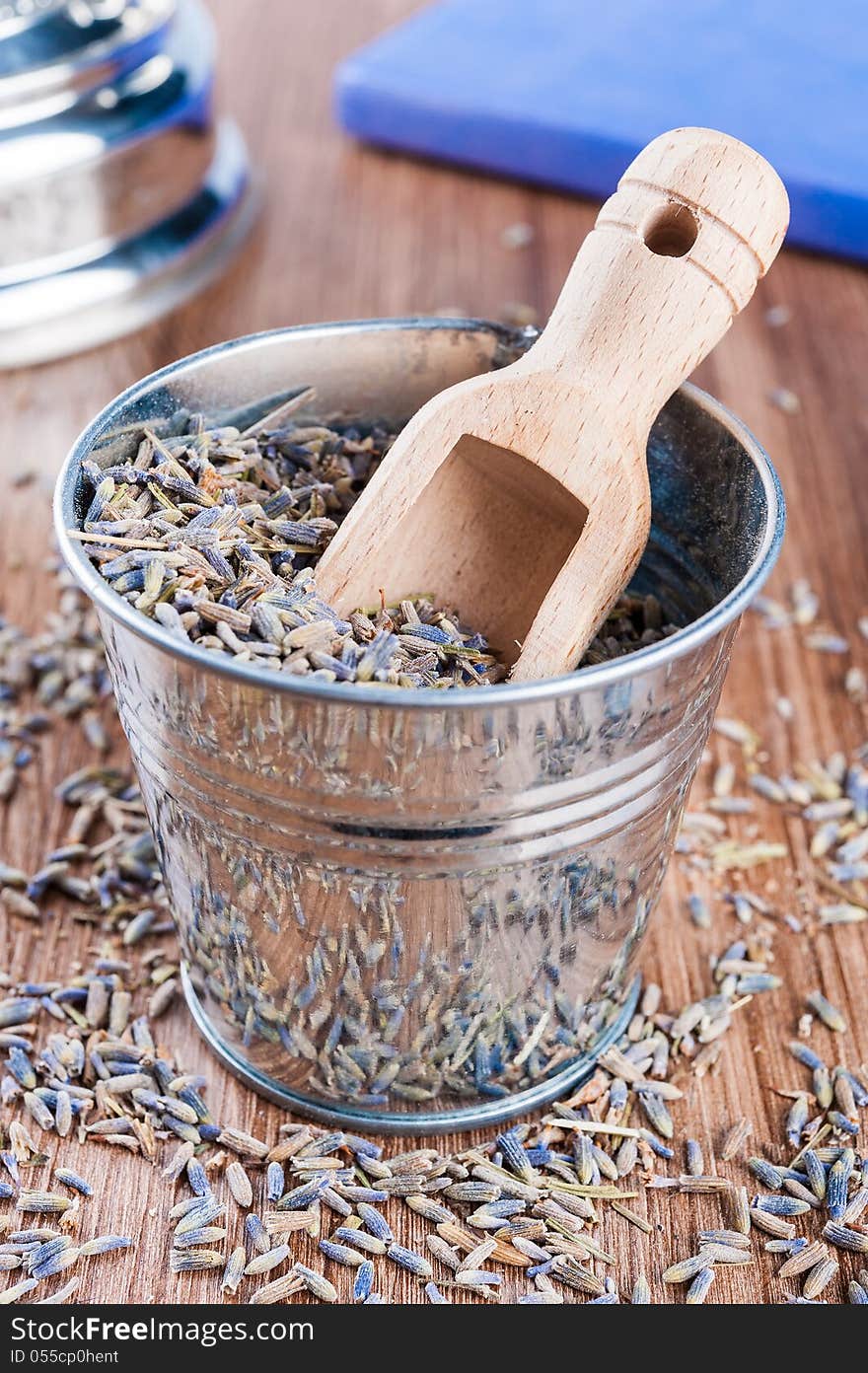 Pail of dry lavender and wooden scoop on a dark wooden background