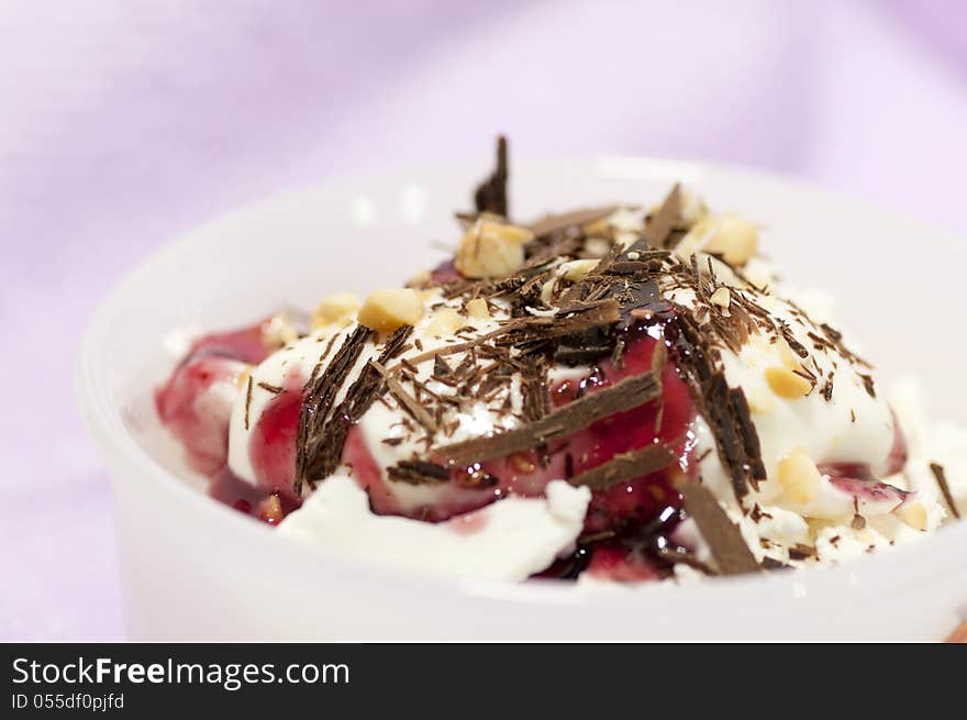 Dessert with cream, chocolate shaving, red jam and grated nuts. Dessert with cream, chocolate shaving, red jam and grated nuts