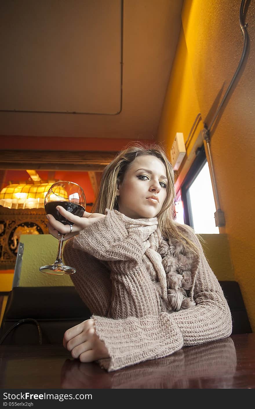 Young Woman with Beautiful Blue Eyes Drinking Red Wine