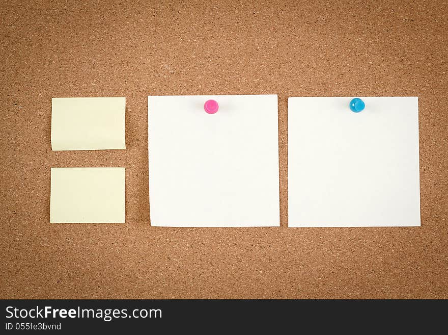 Four empty note papers on cork board