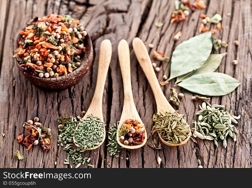 Variety of spices in the spoons on an old wooden table. Variety of spices in the spoons on an old wooden table.