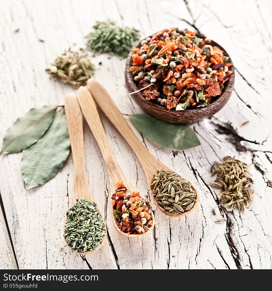 Variety of spices in the spoons on an white old wooden table. Variety of spices in the spoons on an white old wooden table.