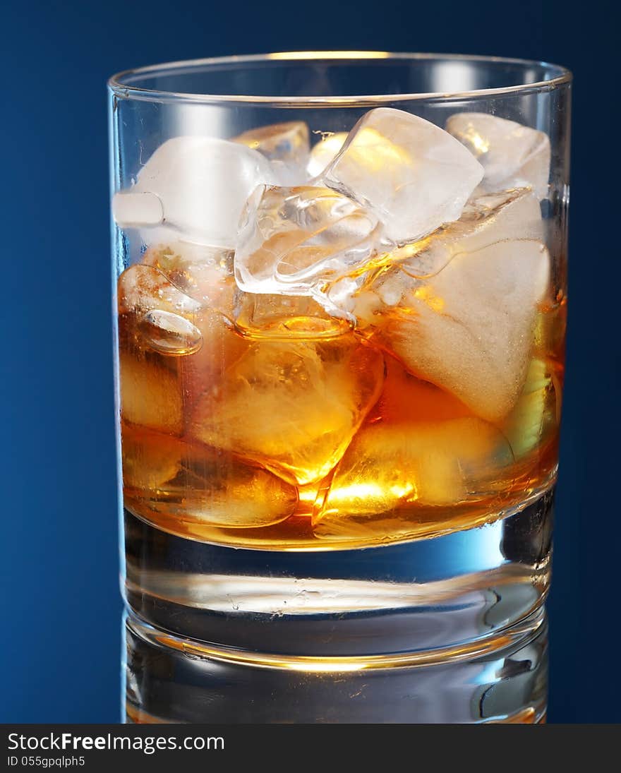 Whiskey glass on a blue background.