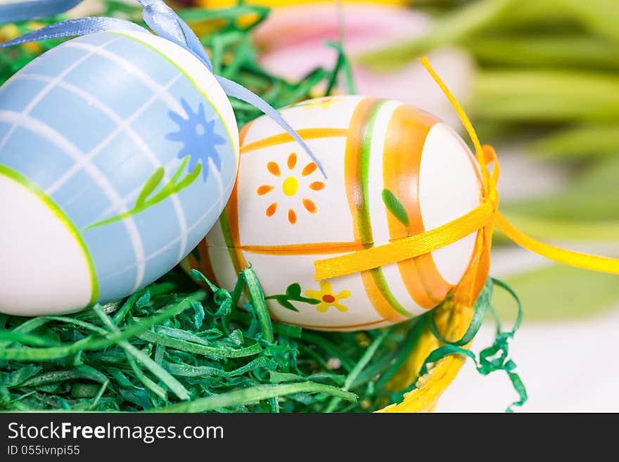 Easter eggs with bows in the basket over floral background