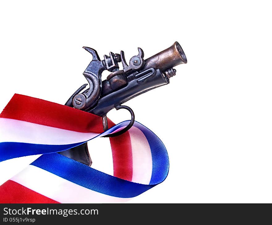 Red white and blue ribbon and antique gun replica. Red white and blue ribbon and antique gun replica.