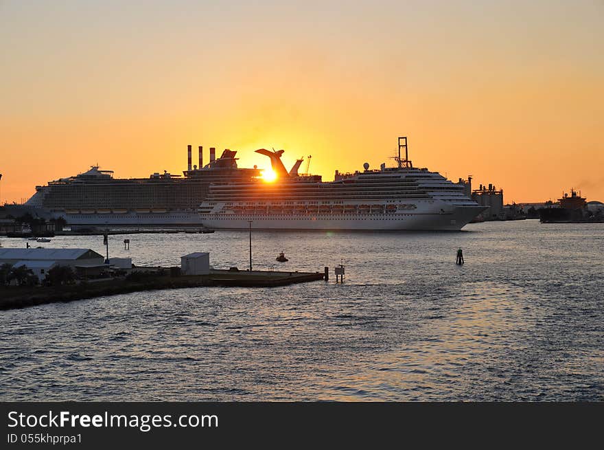 Sun setting over fort lauderdale cruise terminal from a moving cruise ship heading out to sea. Sun setting over fort lauderdale cruise terminal from a moving cruise ship heading out to sea