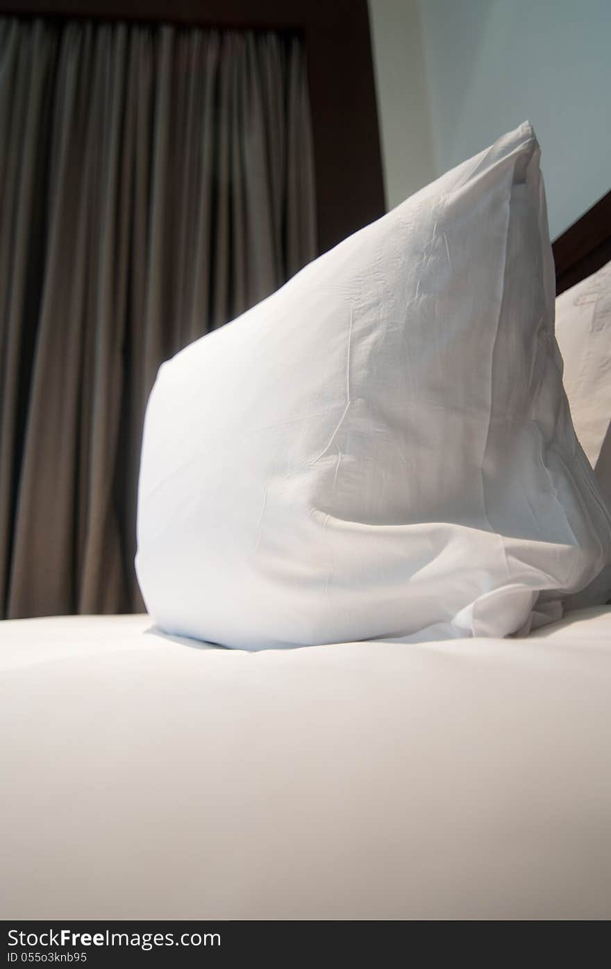 White pillows and bed in white bedroom