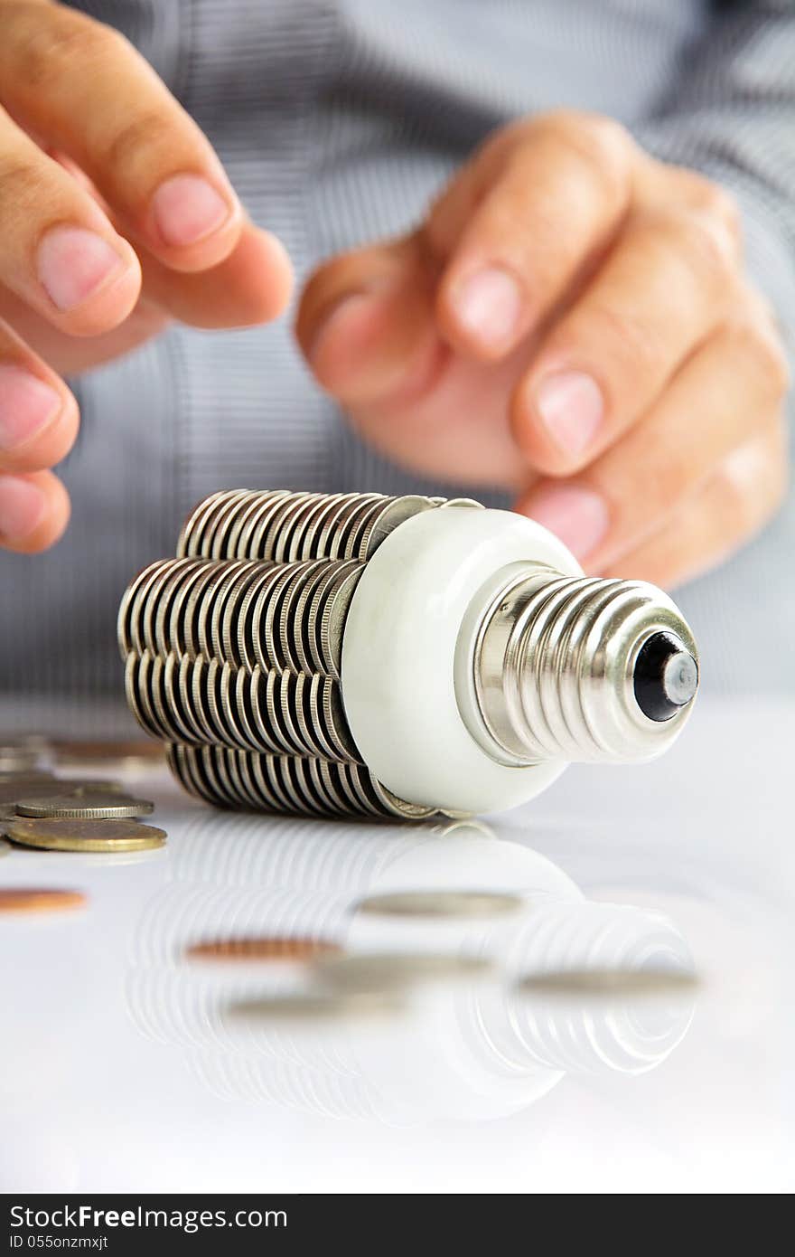 Hand holding coin light bulb