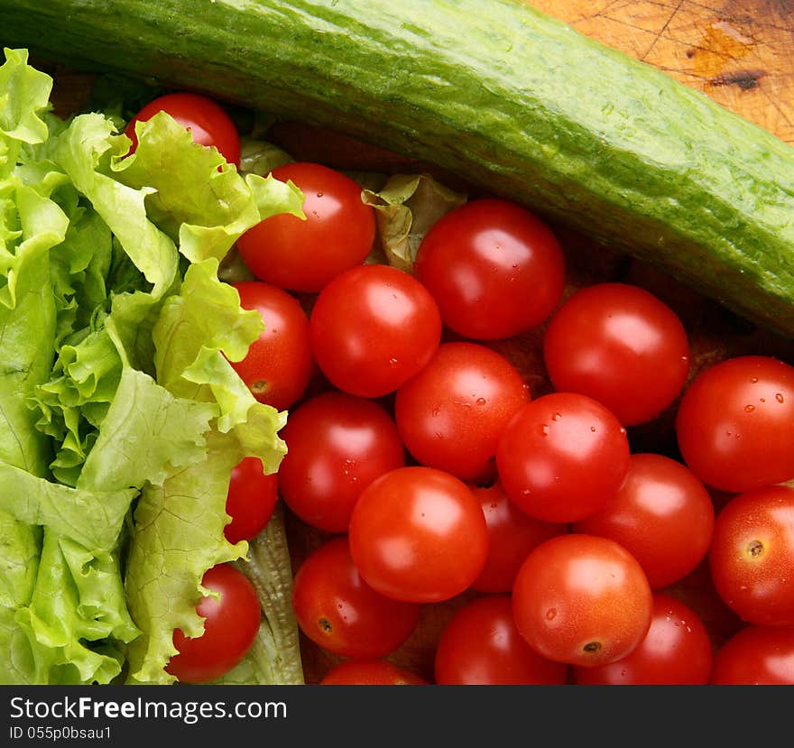 Red ripe cherry tomatoes on a wooden board