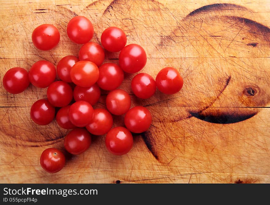 Red cherry tomatoes on a wooden board