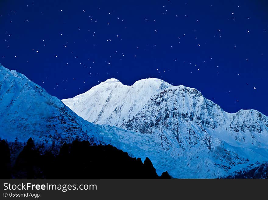 Gangapurna and Annapurna mountains on the blue sky with stars, Himalaya, Nepal