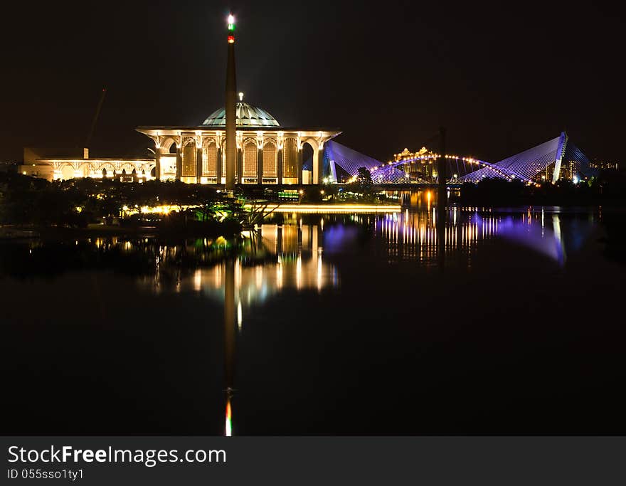 Putrajaya view from putrajaya bridge at night with a reflection of water.