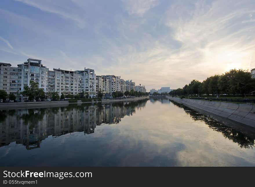 Dambovita river and buildings reflected in water, Bucharest. Romania