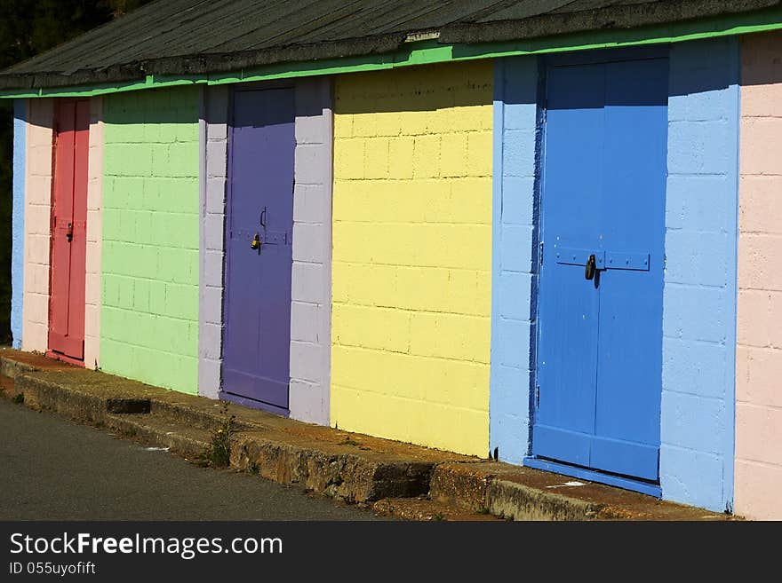 Row of brightly coloured beach huts on coastal walk in Folkestone.