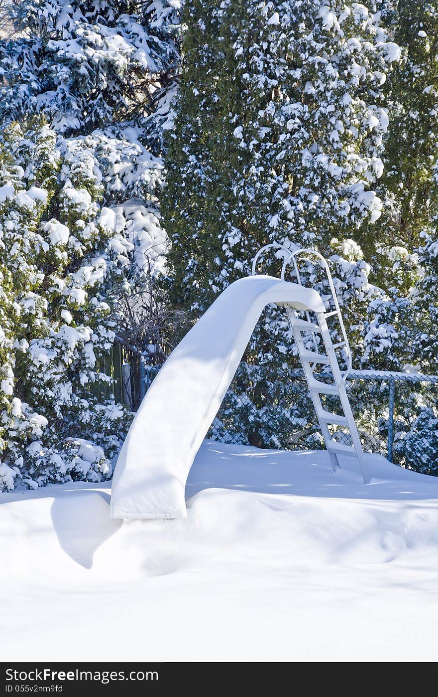 Water by the pool covered with snow, with pine trees as backdrop. Water by the pool covered with snow, with pine trees as backdrop.