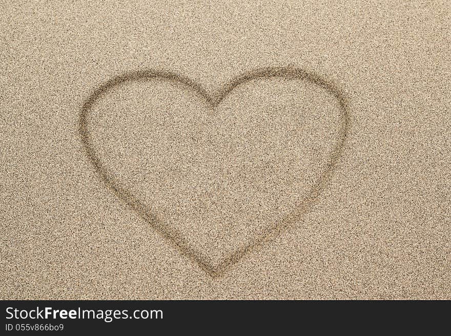 Heart shape symbol drawn in sand