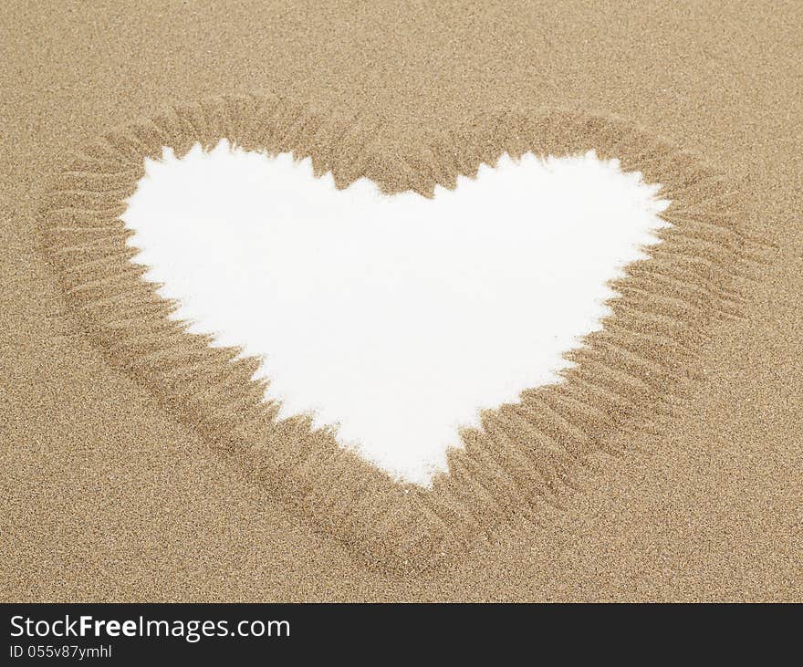 Heart shape drawn in sand with white space for text