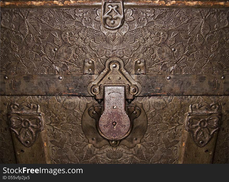 Antique trunk closeup with grape leaf pattern.