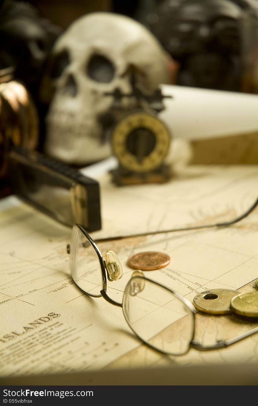 A still life in earthtones with a skull, glasses and an old map. A still life in earthtones with a skull, glasses and an old map.