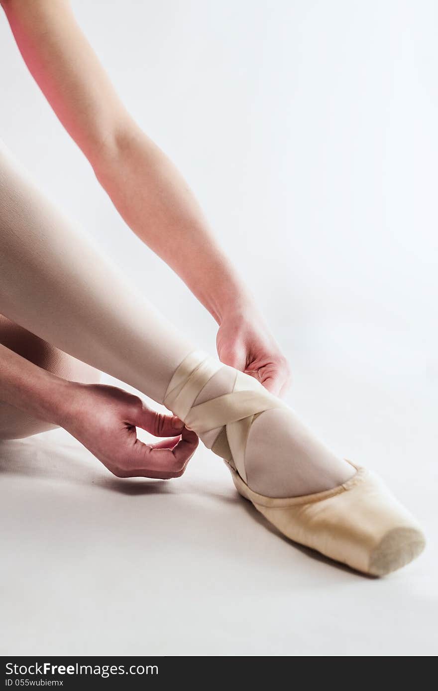 Ballerina preparing her ballet shoes