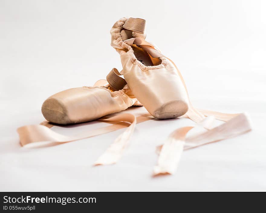 Pink ballet shoes over white background