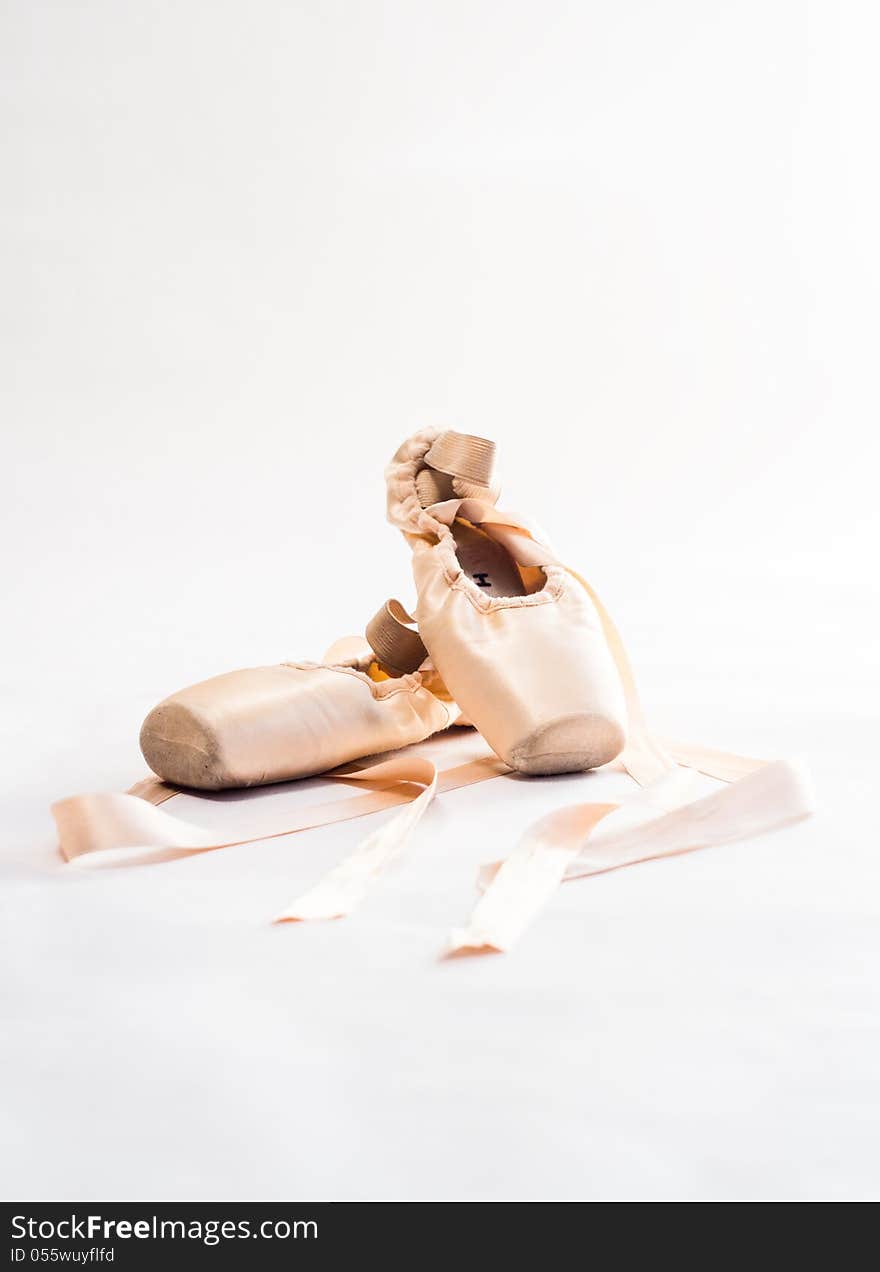 Pink ballet shoes over white background