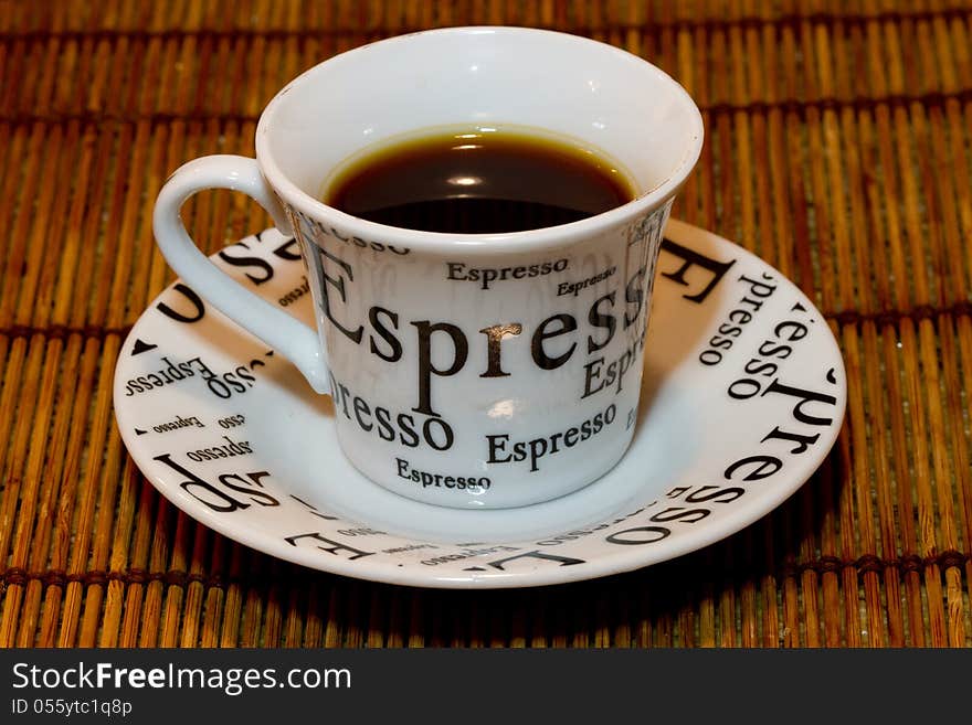 Black espresso in a cup against a bamboo background