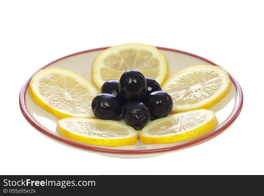 Lemons and olives on a ceramic saucer, isolated on white background. Lemons and olives on a ceramic saucer, isolated on white background