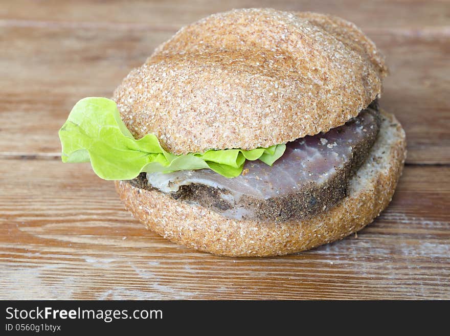 Fresh burger on rough wooden surface. Fresh burger on rough wooden surface