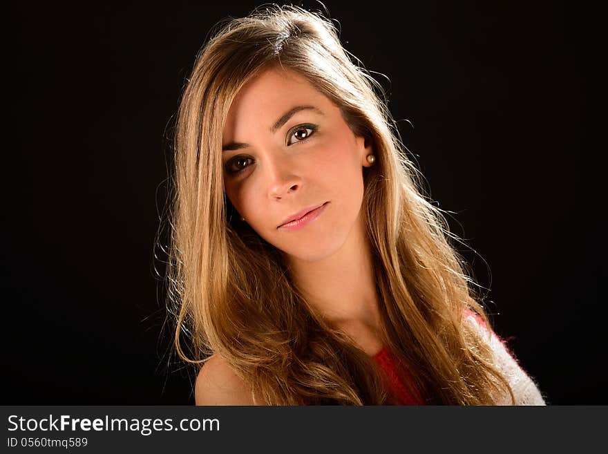 Young blonde woman studio portrait on black background