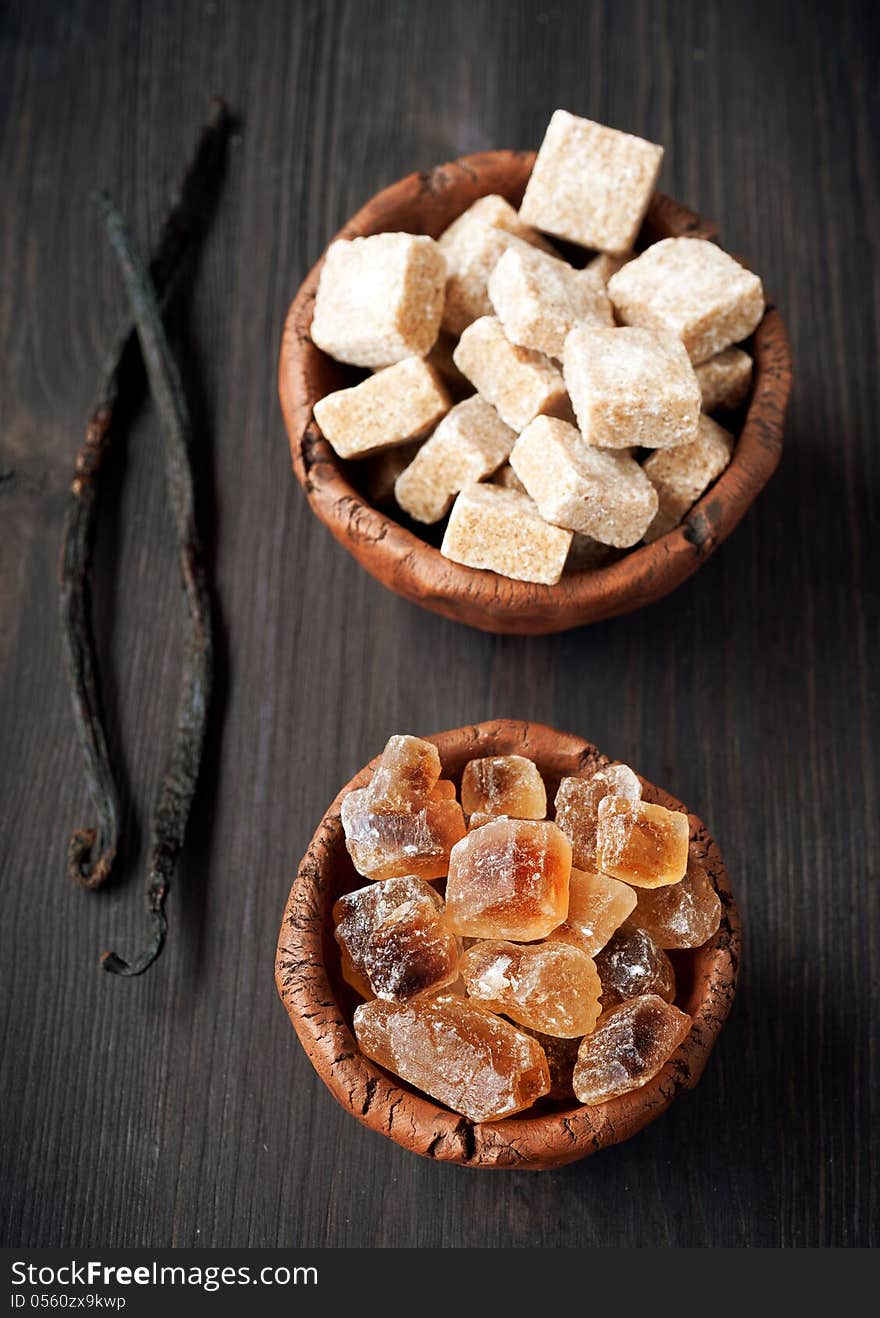 Two types of sugar - brown and cane sugar and vanilla pods. Two types of sugar - brown and cane sugar and vanilla pods