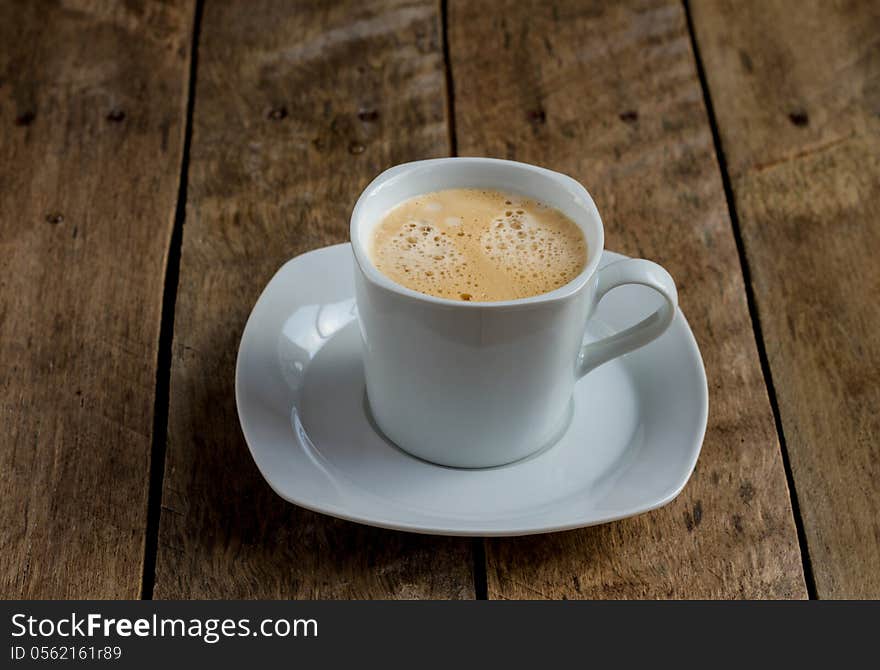 Black Coffee in a white cup and saucer with bubbles. Black Coffee in a white cup and saucer with bubbles.