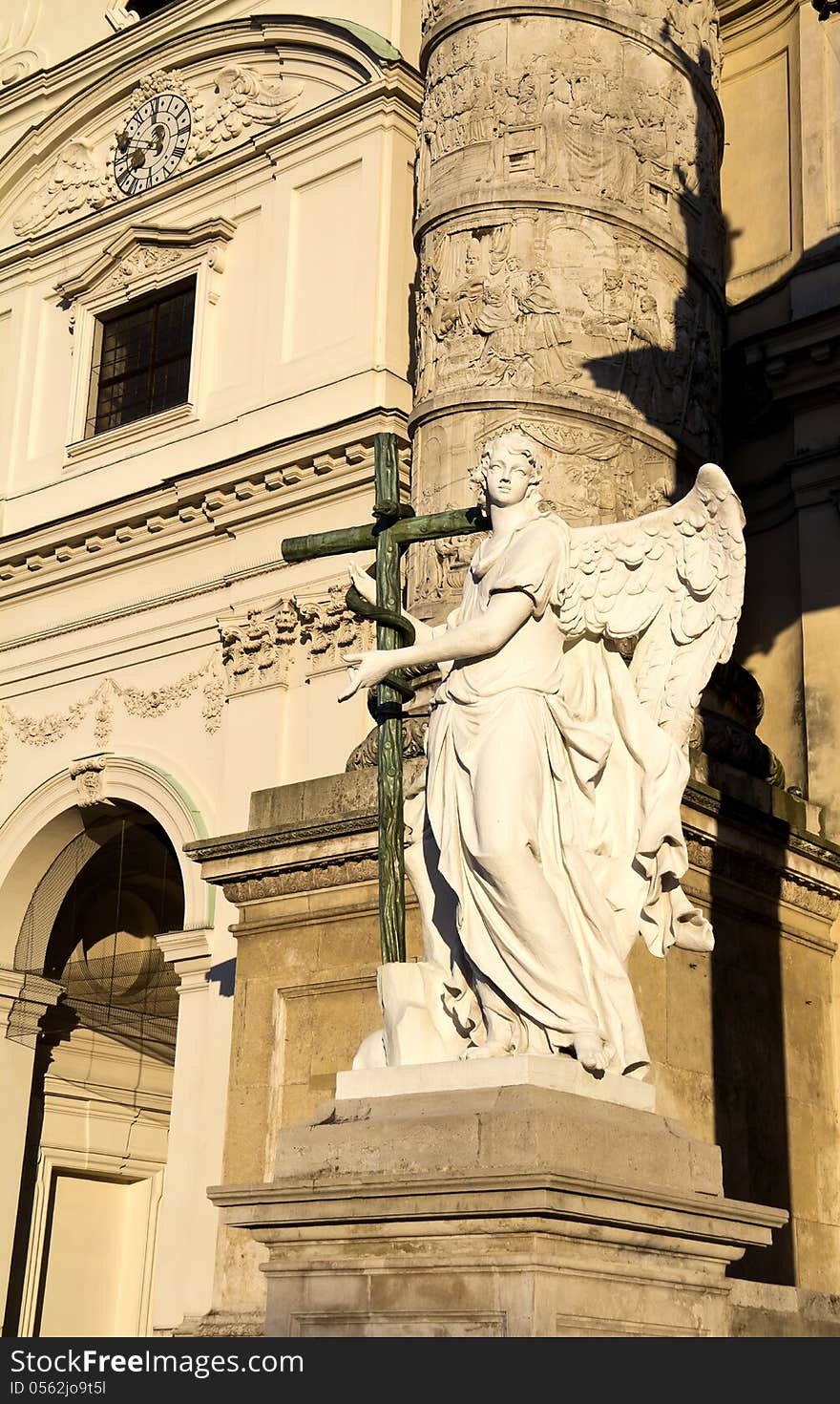 Angel statue with cross in front of Karlskirche (St. Charles's Church), Vienna, Austria