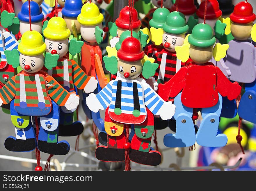 Colorful handmade puppets on display at a street shop