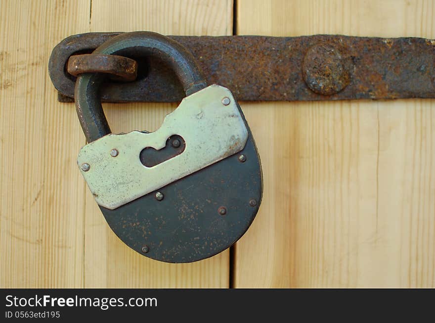 Rusty padlock on wooden door. Rusty padlock on wooden door