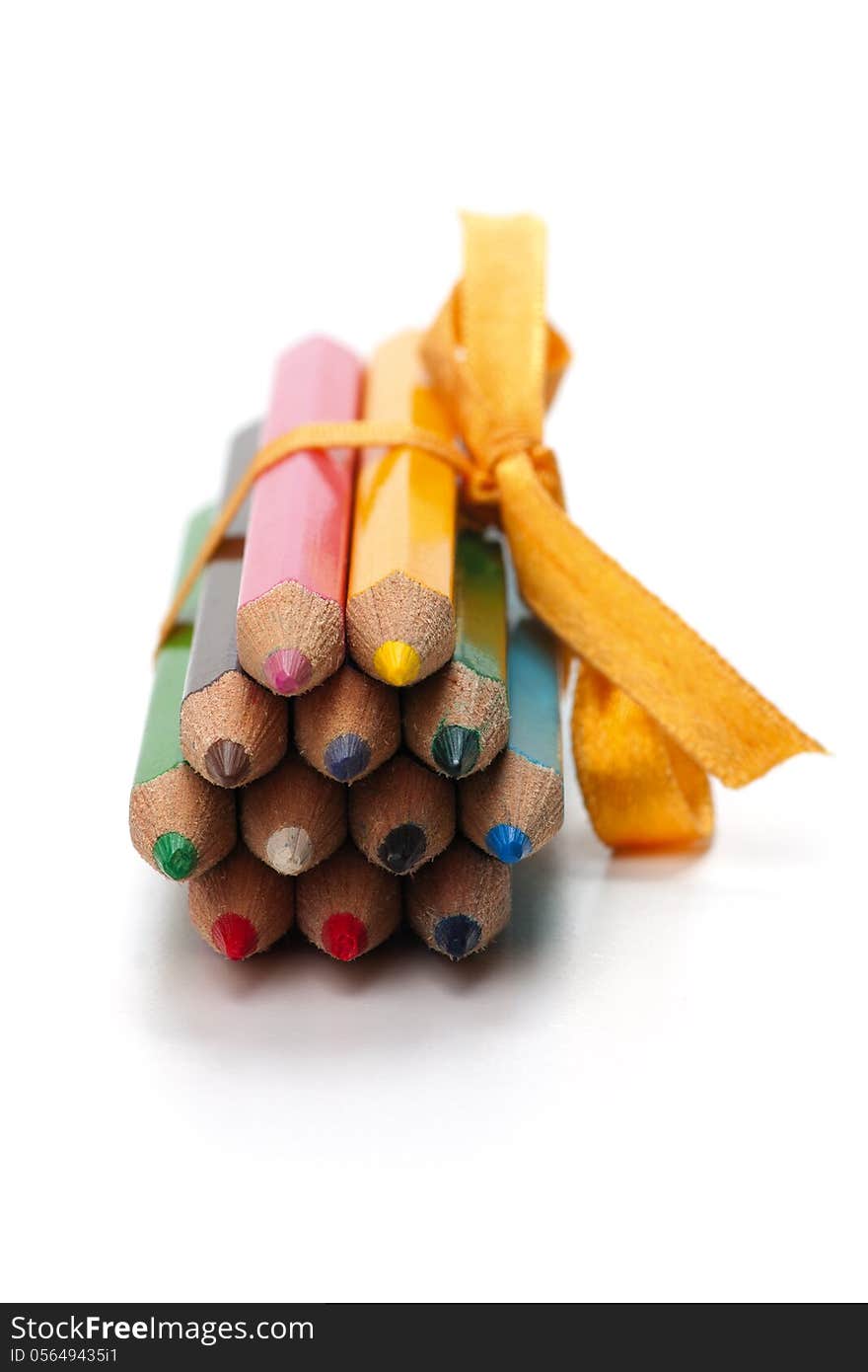 Colored pencils bound together with ribbon. on white background.