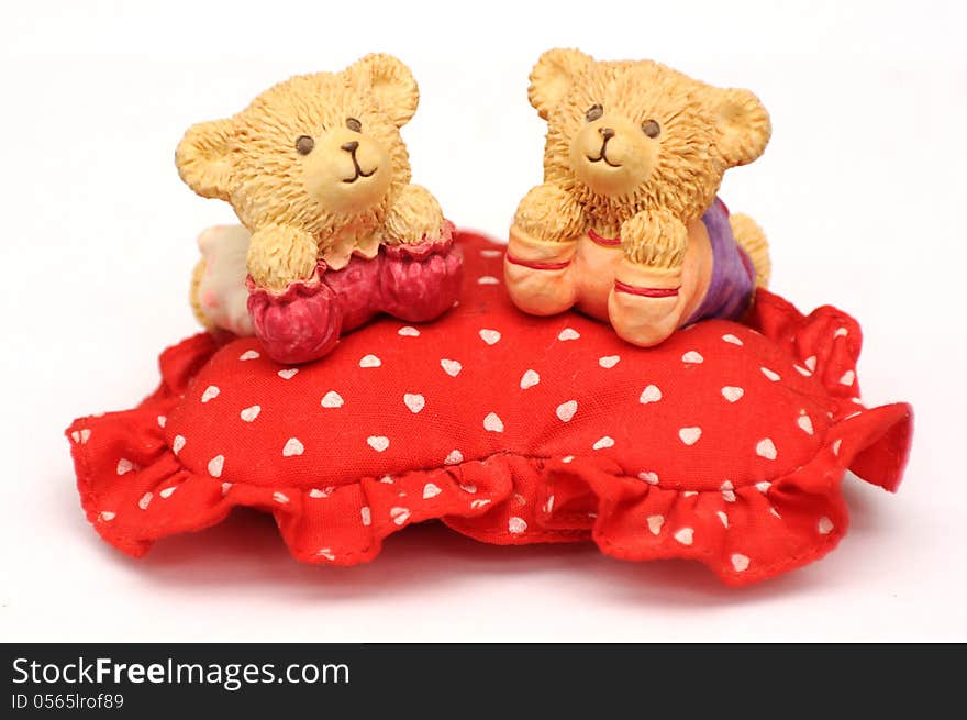 Sweet toy bears over soft heart shaped pillow. Sweet toy bears over soft heart shaped pillow