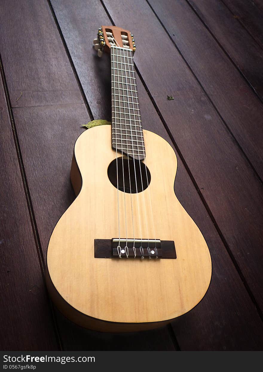 Acoustic guitar on wood surface.