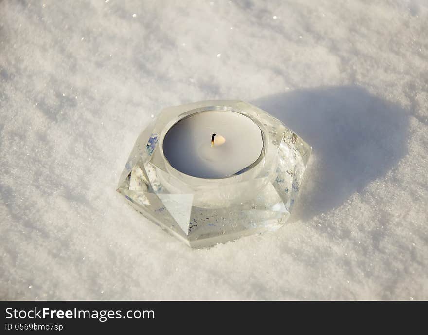 White candle on the snow