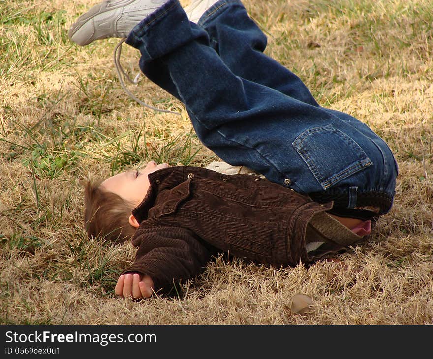 Happy little boy playing and rolling on the grass. Happy little boy playing and rolling on the grass