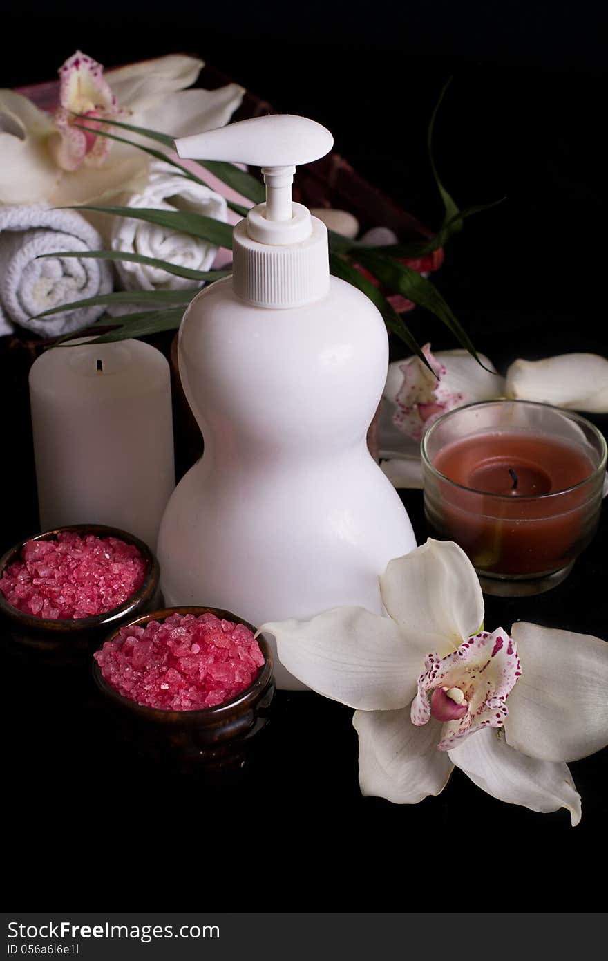 White orchids and spa treatment products on black