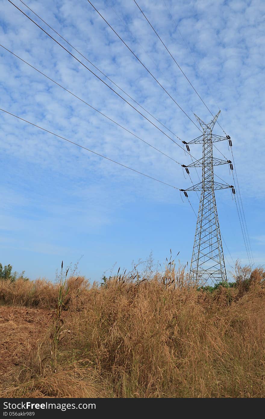 High Voltage power tower line with blue sky in rural area