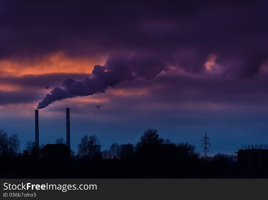 Heavy smoke spewed from the stacks of a coal power plant, profiled on dramatic cloudy sky. Heavy smoke spewed from the stacks of a coal power plant, profiled on dramatic cloudy sky