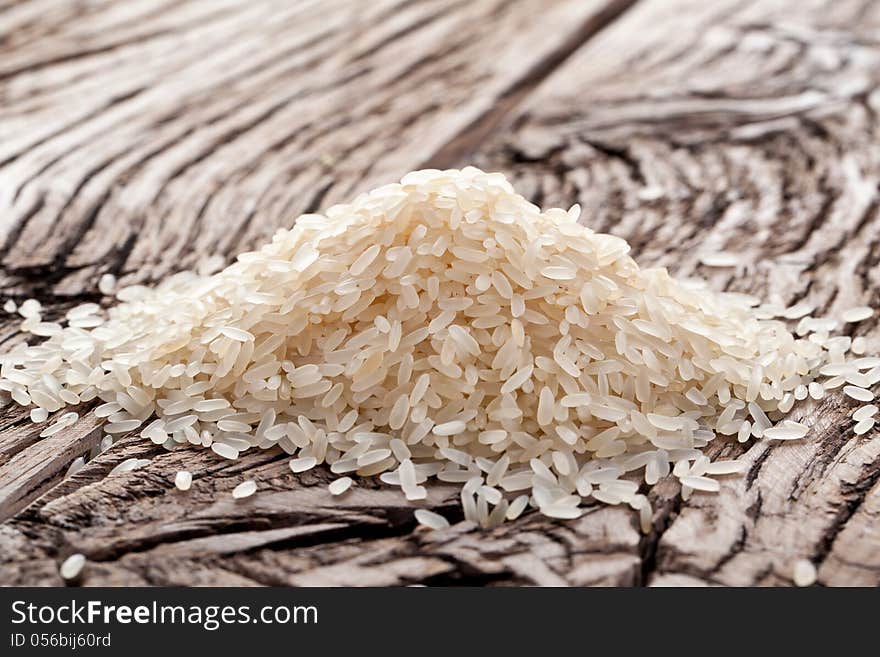 Handful of rice on a wooden table.