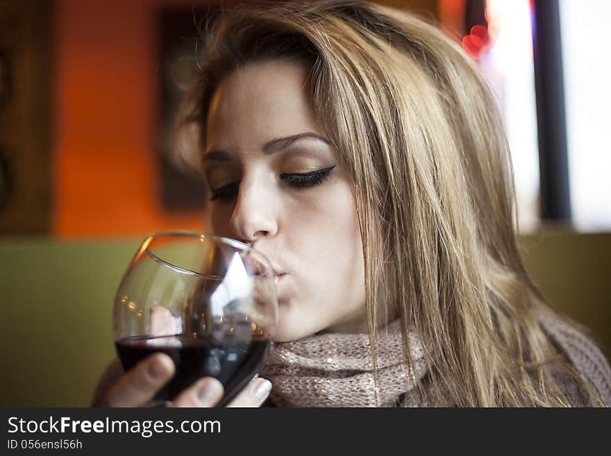 Portrait of a young woman with closed eyes drinking a glass of red wine. Portrait of a young woman with closed eyes drinking a glass of red wine.