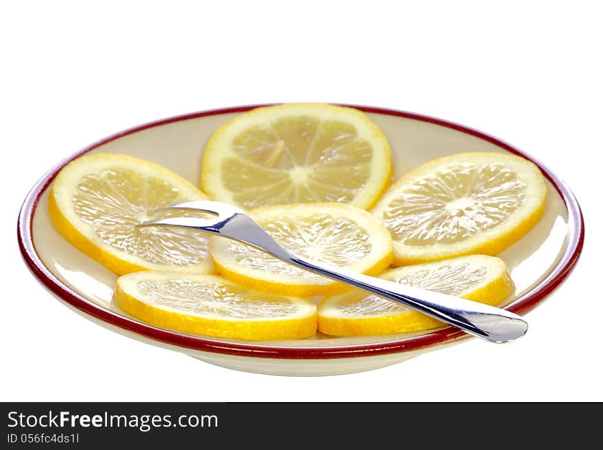 Fork on a plate with lemon isolated on white background