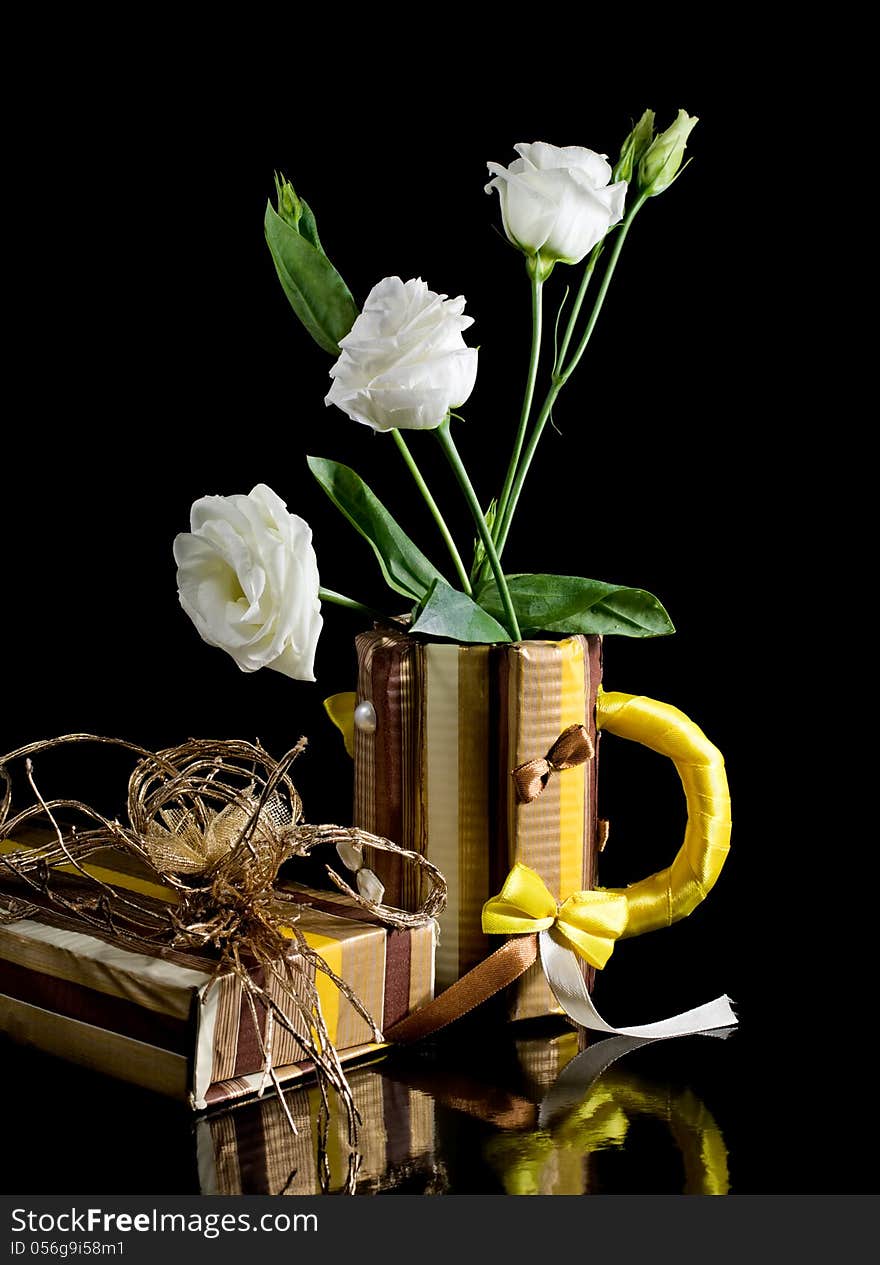 Paper gift box and paper mug with eustoma flowers isolated on a black background