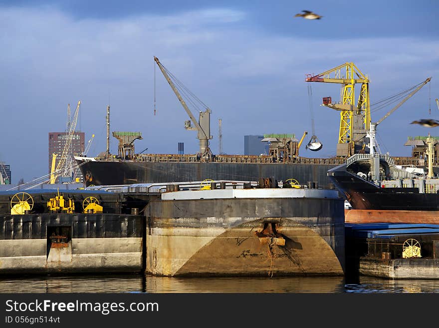 Push barges moored in the port and a bulk carrier is getting loaded in the background