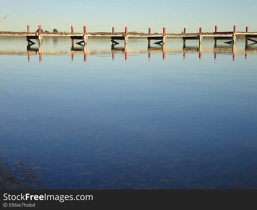 Pier reflected at calm lake