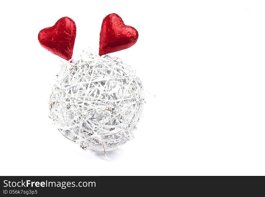 Two red hearts sticking out of a white wicker ball on an isolated white background. Two red hearts sticking out of a white wicker ball on an isolated white background